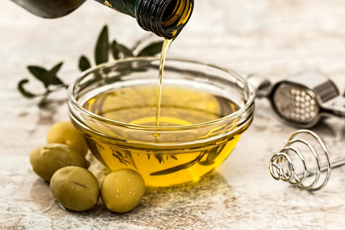 Substitutions alimentaires saines : huile d'olive, légumes, noix et poisson sur une planche