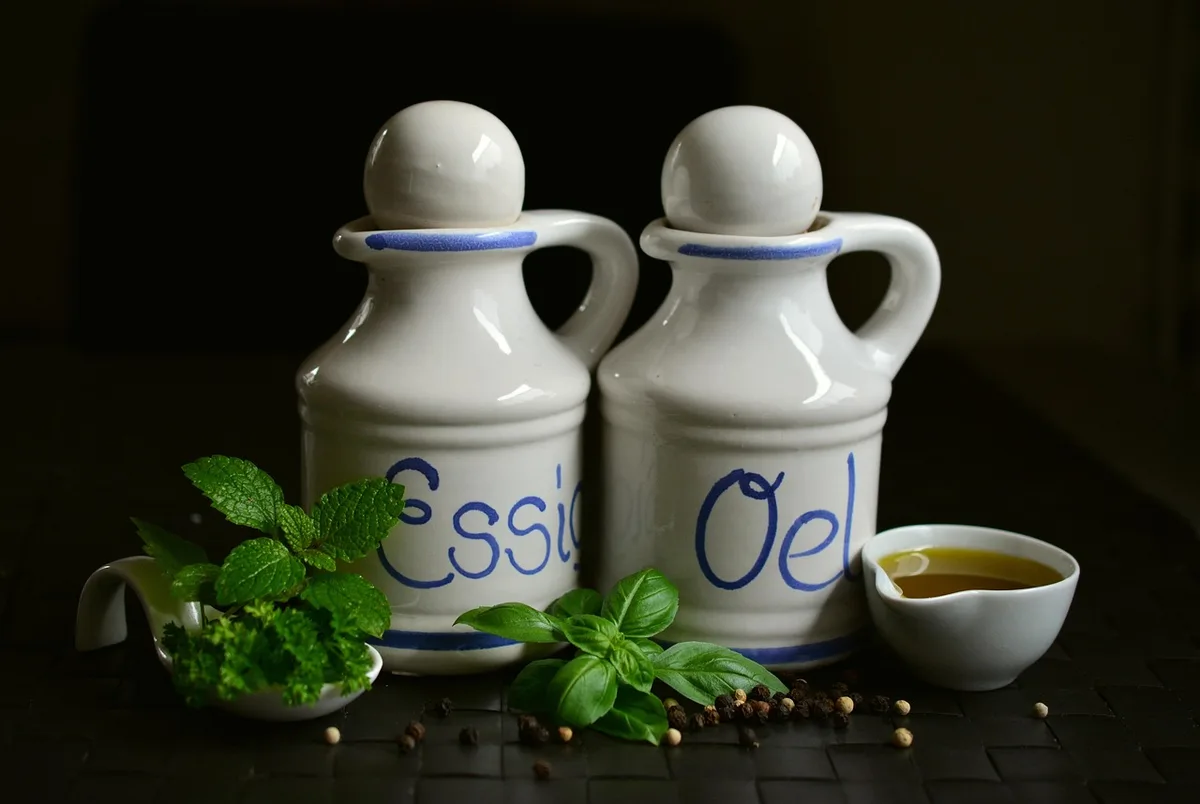 Verre de jus et cuillère à mesurer d'huile près d'une salade