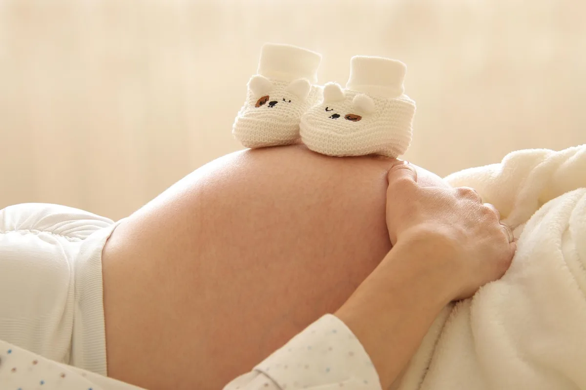 Couple consultant une liste d'achats bébé dans un salon lumineux