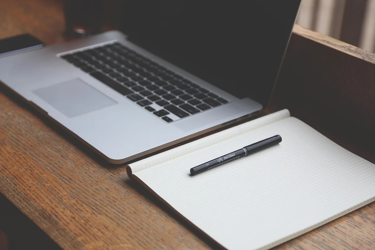 Ordinateur avec webcam et smartphone posé sur un bureau lumineux